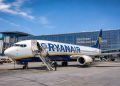 Avion Boeing 737 de la compagnie Ryanair en attente d'embarquement des passagers sur le tarmac d'un aéroport européen ensoleillé en 2026.