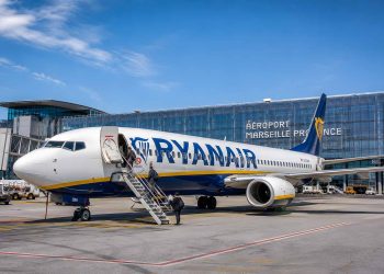 Avion Boeing 737 de la compagnie Ryanair en attente d'embarquement des passagers sur le tarmac d'un aéroport européen ensoleillé en 2026.