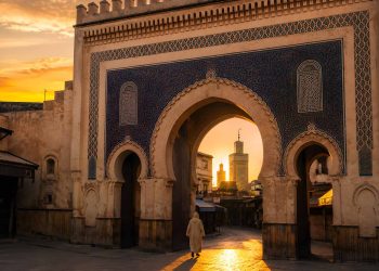 Vue de la porte historique monumentale Bab Boujloud ornée de zelliges bleus à l'entrée de la médina de Fès au lever du soleil.