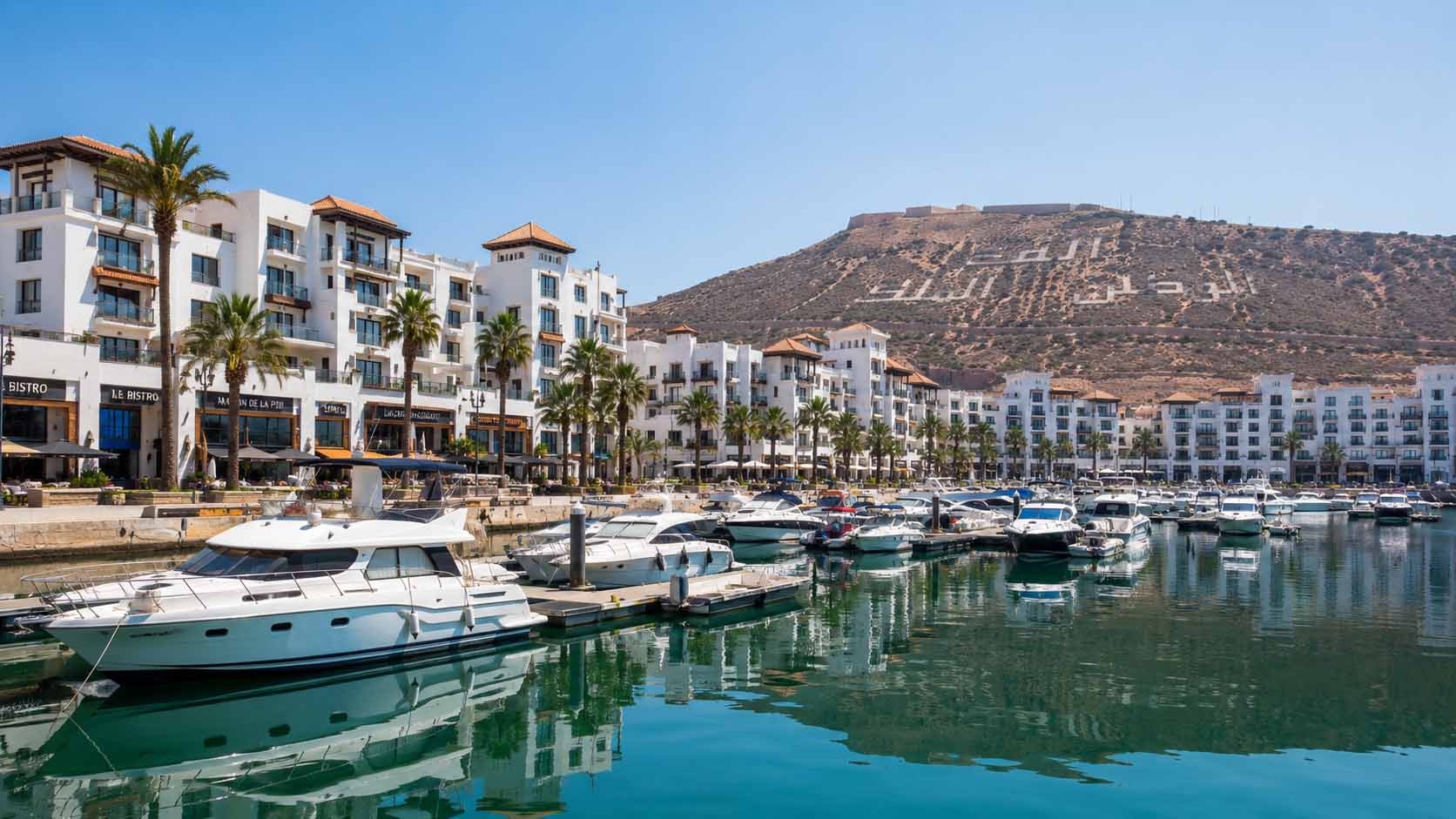Tanger ou Agadir : laquelle choisir pour un premier voyage au Maroc ? 4 Marina moderne d'Agadir avec des appartements de standing blancs et des yachts amarrés au port.