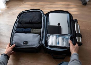Ce que j'ai vraiment mis dans mon bagage cabine après 15 voyages (Ma liste complète 2026) 5 Un sac à dos de voyage ouvert à plat dévoilant une organisation optimisée avec des cubes de rangement et des accessoires de voyage.
