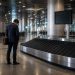Bagage perdu à l'aéroport : comment j'ai réussi à le récupérer 6 Un voyageur seul devant un tapis de livraison de bagages vide dans un grand terminal d'aéroport international.
