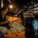 Bangkok après minuit : ce que j'ai découvert en dehors des circuits touristiques 11 Une vendeuse locale triant des fleurs au marché de Pak Khlong Talat à Bangkok à 2 heures du matin, illustrant la vie nocturne authentique loin du tourisme de masse.