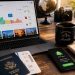 J'ai testé 10 astuces pour payer moins cher mes billets d'avion : lesquelles fonctionnent vraiment ? 6 Espace de travail d'un journaliste voyage avec un ordinateur affichant des graphiques de prix de billets d'avion et un smartphone affichant une alerte de prix.