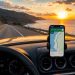 Comment Google Maps m'a sauvé pendant mon road trip 5 Smartphone affichant la navigation Google Maps sur le tableau de bord d'une voiture roulant sur une route côtière au coucher du soleil lors d'un road trip.
