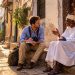 Les erreurs que j'ai évitées à Zanzibar grâce aux conseils des habitants 10 Journaliste de voyage discutant avec un habitant swahili sur un banc traditionnel à Stone Town, Zanzibar.
