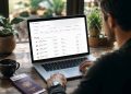 Journaliste voyage comparant les prix des billets d'avion sur son ordinateur portable pour économiser sur son budget.