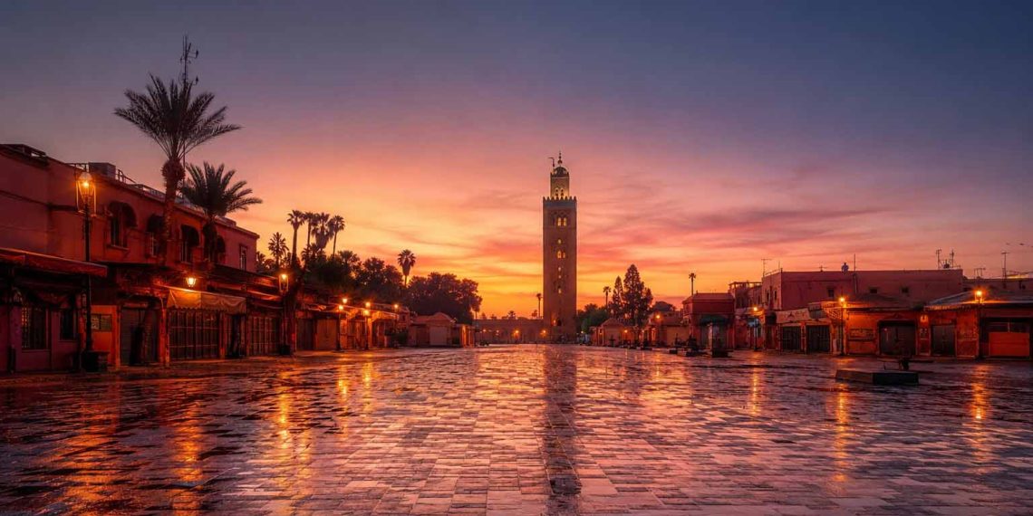 J'ai exploré Marrakech avant 8 h du matin : une ville totalement différente 1 Vue panoramique de la place Jemaa el-Fna vide au lever du soleil à Marrakech avec le minaret de la Koutoubia en arrière-plan.