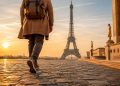 Une personne marchant à pied sur l'esplanade du Trocadéro face à la Tour Eiffel au lever du soleil à Paris.