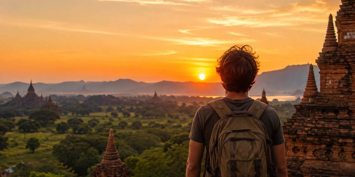 Les pays où j'ai dépensé le moins d'argent 1 Un voyageur avec sac à dos explore l'un des pays les moins chers pour voyager à petit budget au coucher du soleil.