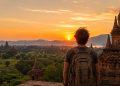 Un voyageur avec sac à dos explore l'un des pays les moins chers pour voyager à petit budget au coucher du soleil.