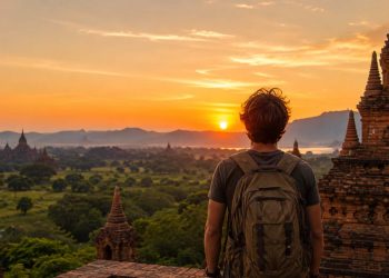 Les pays où j'ai dépensé le moins d'argent 2 Un voyageur avec sac à dos explore l'un des pays les moins chers pour voyager à petit budget au coucher du soleil.