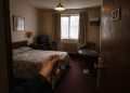 Vue depuis l'entrée d'une chambre d'hôtel décevante illustrant les erreurs de réservation de voyage.