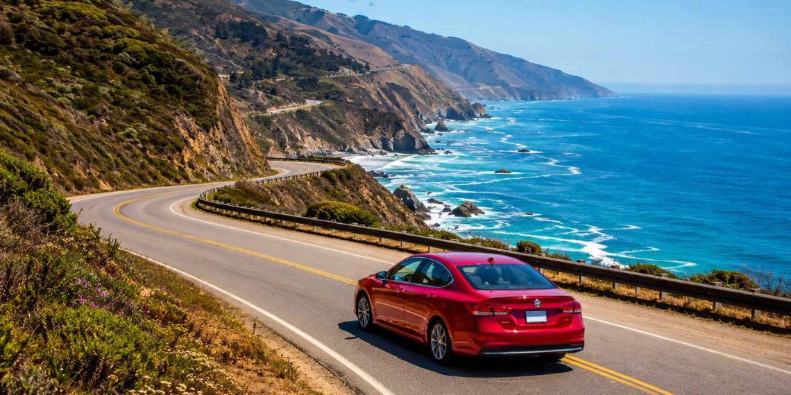 J'ai traversé la Californie en voiture : mon itinéraire complet, mon budget et tous mes conseils (Guide 2026) 1 Voiture de location sur la route côtière Pacific Coast Highway pendant un road trip en Californie face à l'océan Pacifique.