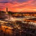 Une semaine à Marrakech : tout ce que j'ai appris (Guide complet, budget et conseils 2026) 6 Vue panoramique de la place Jemaa el-Fna à Marrakech au coucher du soleil avec les stands de nourriture fumants et la mosquée Koutoubia.