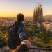 J'ai visité Barcelone avec seulement 350 € : mon budget détaillé et mes astuces (Guide 2026) 6 Une voyageuse avec un sac à dos contemple la ville de Barcelone et la Sagrada Família au lever du soleil.