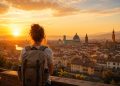 Voyageur sac au dos contemplant une ville historique européenne au lever du soleil pour un voyage pas cher sous la barre des 500 euros.