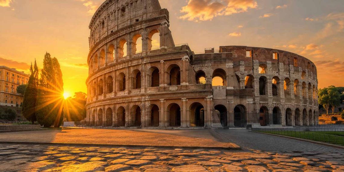 5 erreurs qui ont presque gâché mon voyage à Rome 1 Vue grand angle du Colisée de Rome baigné par la lumière dorée du lever du soleil, illustration pour un guide de voyage réussi sans erreurs logistiques.