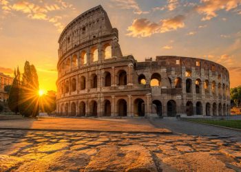 5 erreurs qui ont presque gâché mon voyage à Rome 5 Vue grand angle du Colisée de Rome baigné par la lumière dorée du lever du soleil, illustration pour un guide de voyage réussi sans erreurs logistiques.
