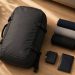 J'ai voyagé uniquement avec un sac à dos pendant 30 jours : ce que j'ai appris 6 Sac à dos de voyage de 40 litres posé à plat sur un parquet avec des vêtements minimalistes roulés en laine mérinos.