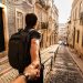 J'ai voyagé en Europe avec seulement un sac à dos : mon retour d'expérience, budget et conseils (Guide 2026) 3 Voyageur portant un unique sac à dos technique de voyage dans une rue pavée historique d'une ville européenne.