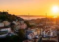 Vue d'ensemble panoramique sur les toits de Lisbonne au lever du soleil avec le Tage en arrière-plan.